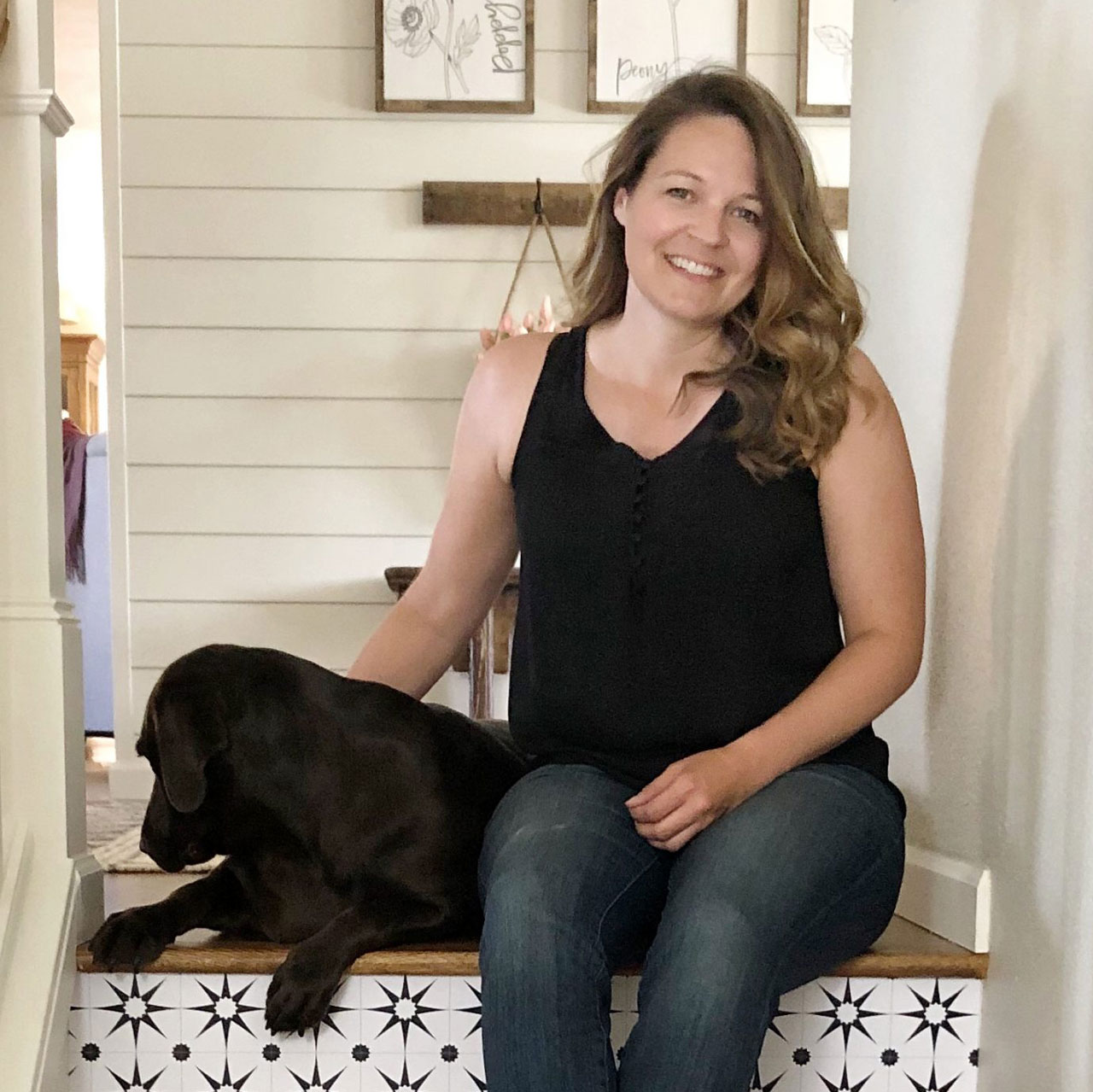 Tammy Delbridge sitting on some stairs with a black dog